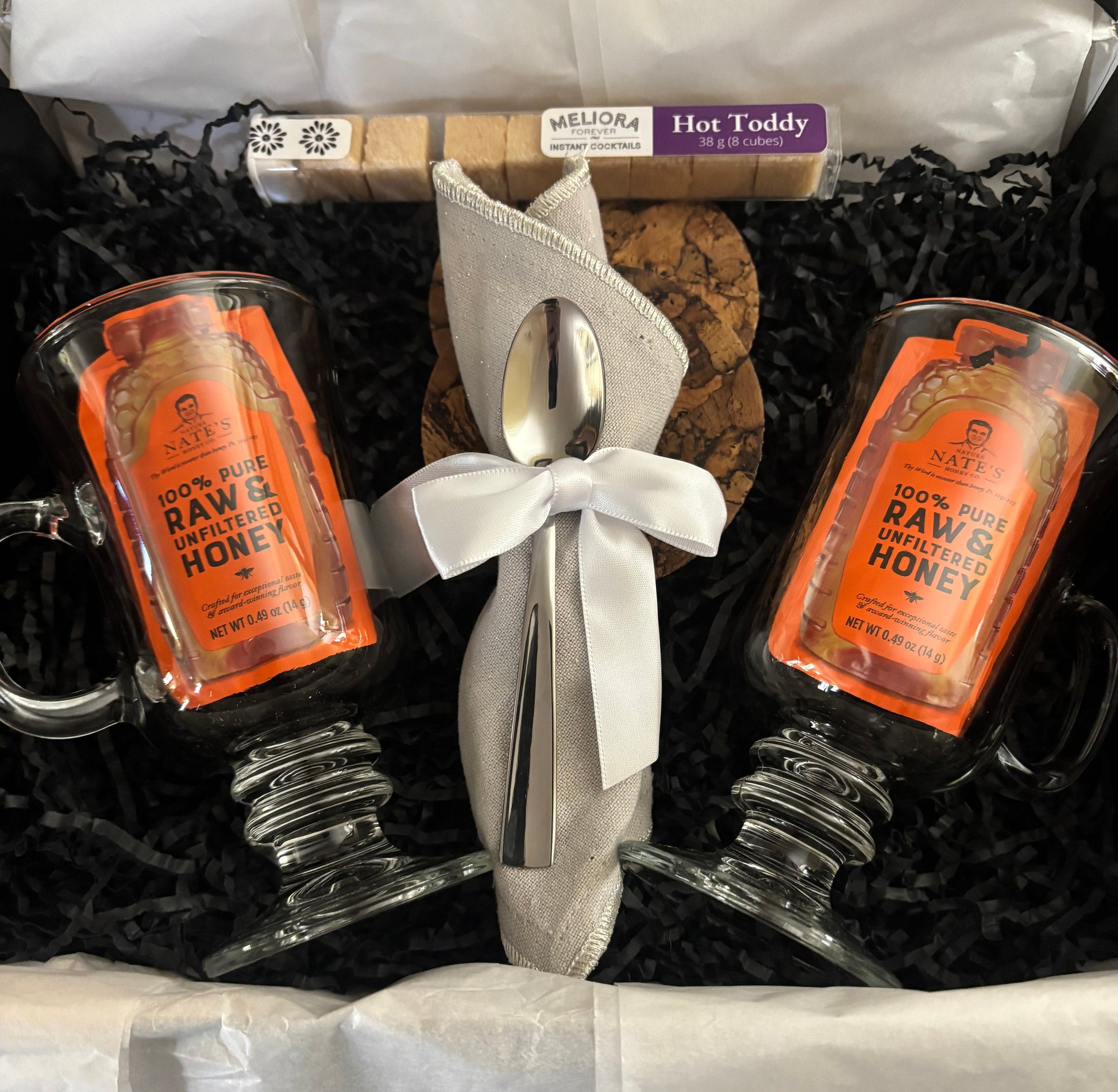 Gift Box spoon and cork on a black surface.