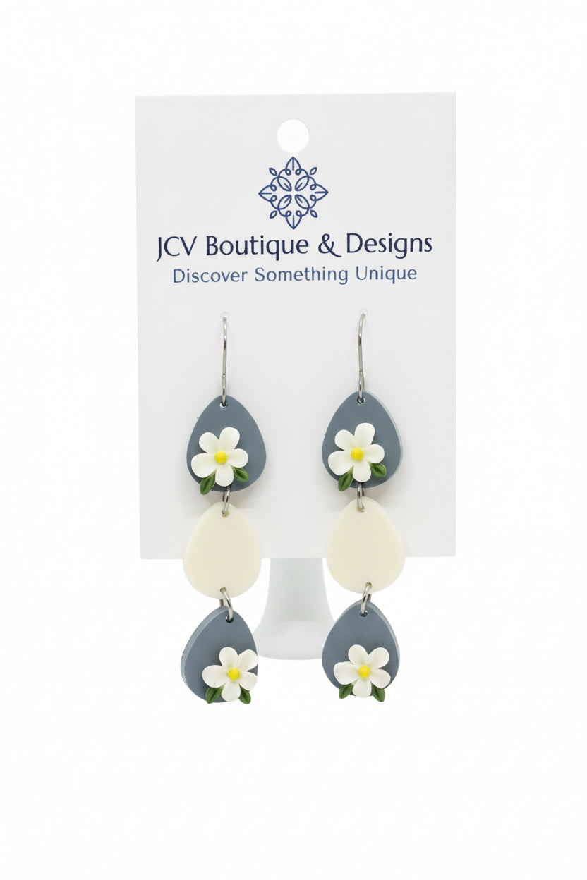 Earrings with floral designs on a white card with 'JW Boutique & Designs' branding.