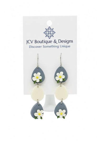 Earrings with floral designs on a white card with 'JW Boutique & Designs' branding.