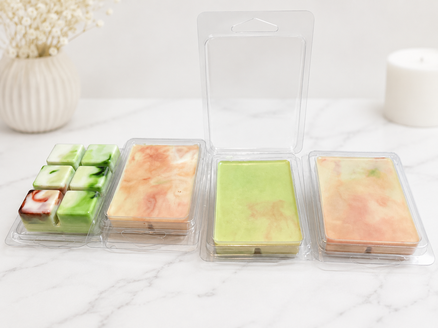 Four rectangular soap bars in clear packaging on a white surface.